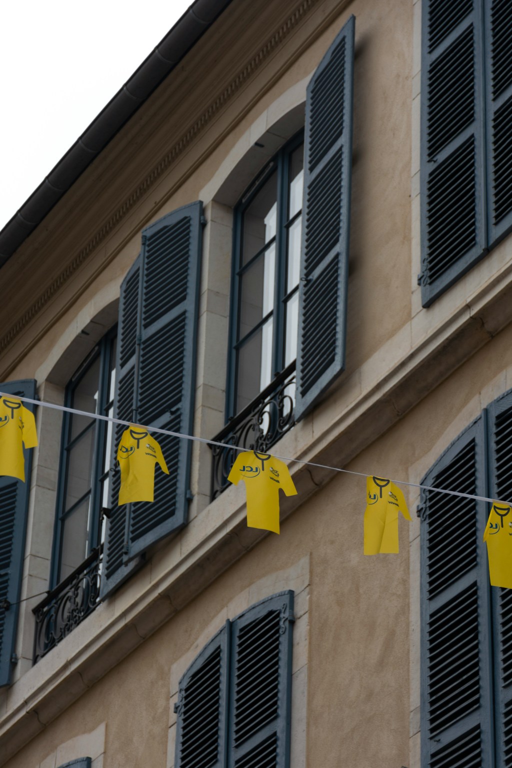 The iconic yellow jersey of the Tour de France hanging from an apartment window in France.